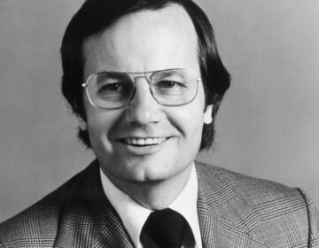 A black and white studio headshot portrait of a young Bill Moyers.