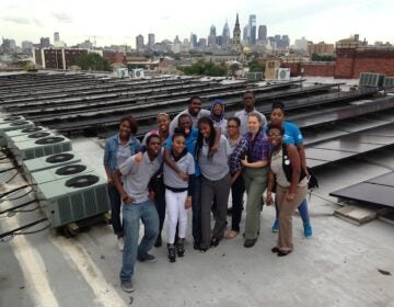 students on the roof with solar panels set up