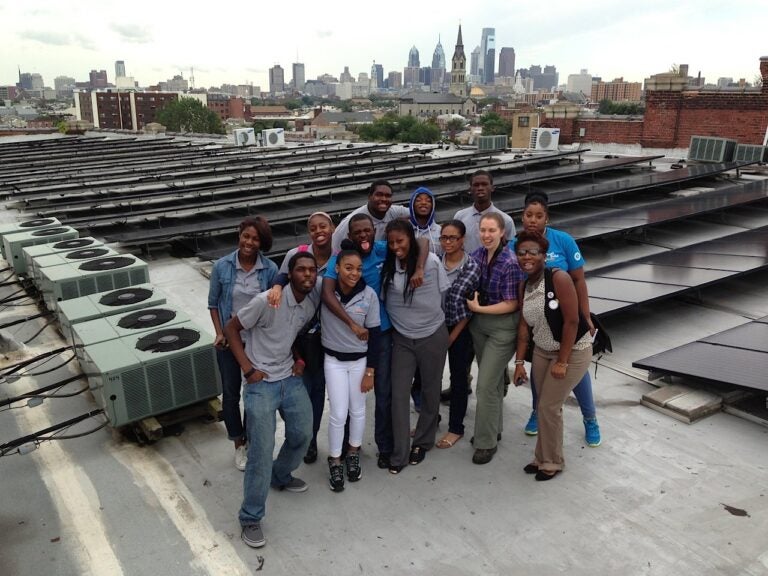 students on the roof with solar panels set up