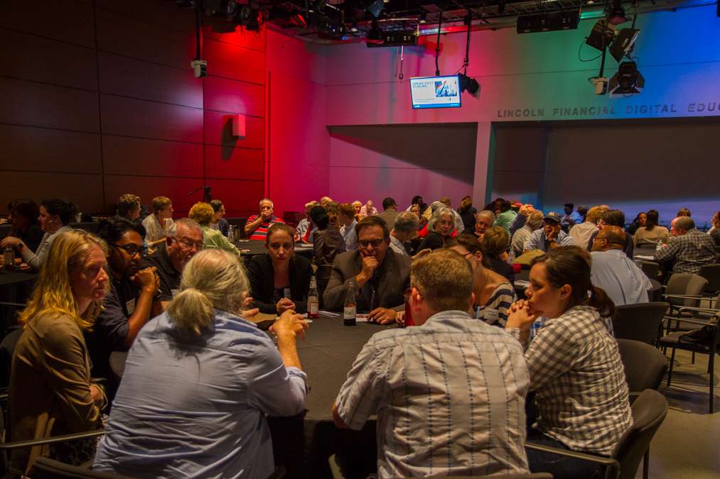 Guests filled the Lincoln Financial Digital Education Studio at WHYY for the public forum 'LGBT Priorities Beyond Marriage.' Panelist Dawn Munro (blue shirt, ponytail) is shown in the foreground. (Ifanyi Bell/for NewsWorks)