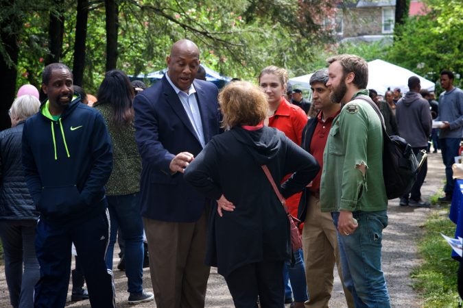 East Mt Airy resident Elayne Bender (seen on back) and West Mt Airy resident Bradley Maule (right) talk to Congressman-elect Dwight Evans as he tours Mt Airy Day with former MAUSA Exec. Director Anuj Gupta. (Bastiaan Slabbers for WHYY)