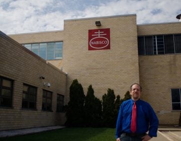 Ross Feinberg poses in front of the shuttered Nabisco Factory on Roosevelt Boulevard. It closed in 2015. (Alex Lewis/Every ZIP gPhiladelphia)