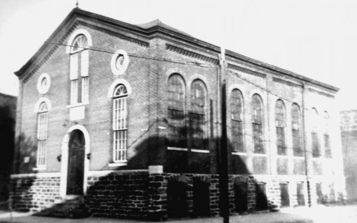 The synagogue served the early Jewtowners. The two story building was the gathering place for Jews who arrived in Newtown after fleeing from Russia in the late 1800s. An entrance to a small courtyard led to the basement and the social hall, which had a small chapel, heated by a potbelly stove, where the men prayed in winter. (Courtesy of Carl Nathans)