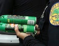 a Miami police officer carries bug spray