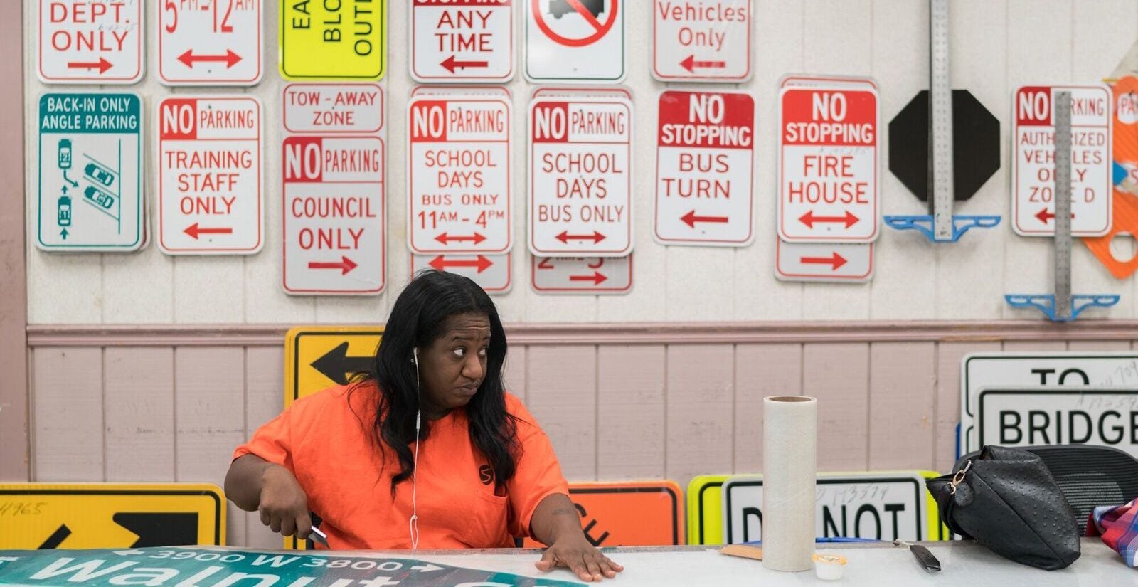 Marquita Alleyne cuts out a street sign at the Traffic Signal and Sign Shop. (Branden Eastwood for WHYY)