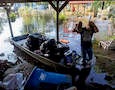 A boy stands in a flooded backyard