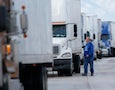 a truck driver standing by a row of trucks