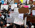 a crowd protests the airport ban