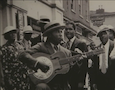 a man strums a banjo in an old photograph