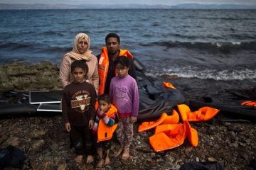 Iraqi refugee Mohammed Sadoun, 39, and his wife Suhad, 35, who came from Mosul, Iraq, pose for a picture with their children shortly after arriving on a dinghy from the Turkish coast to the northeastern Greek island of Lesbos. “We had to run from Islamic State, IS, death will reach us all if we don’t. I wish to reach Germany where humanity exists, and my children will grow up with a bright future,” Mohammed Sadoun said. (AP Photo/Muhammed Muheisen)