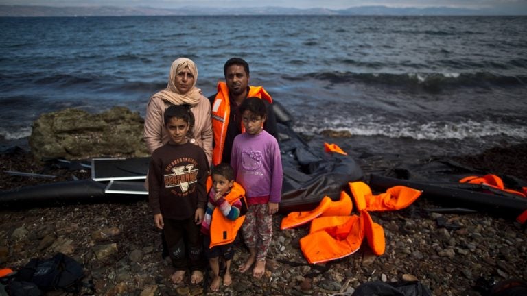 Iraqi refugee Mohammed Sadoun, 39, and his wife Suhad, 35, who came from Mosul, Iraq, pose for a picture with their children shortly after arriving on a dinghy from the Turkish coast to the northeastern Greek island of Lesbos. “We had to run from Islamic State, IS, death will reach us all if we don’t. I wish to reach Germany where humanity exists, and my children will grow up with a bright future,” Mohammed Sadoun said. (AP Photo/Muhammed Muheisen)