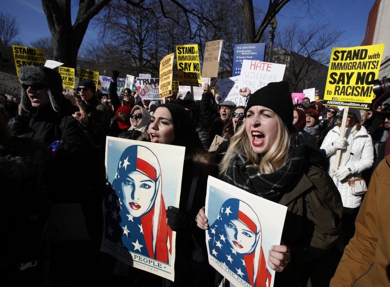 Martha Obermiller of Denver, right, chants during a rally protesting the immigration policies of President Donald Trump, near the White House in Washington, Saturday, Feb. 4, 2017.
