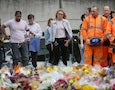 City workers and others stand after laying flower tributes in the London Bridge area of London