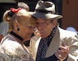 an elderly couple dances.
