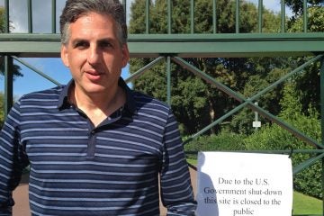  Robert Fox of Lower Merion, Pa., stands outside of the Normandy burial ground at Omaha Beach in France, closed because of the U.S. federal government shutdown.  (Photo courtesy of Robert Fox) 