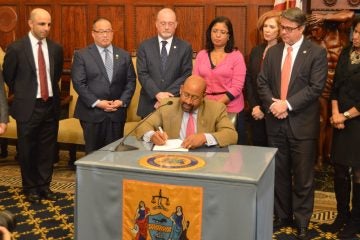  Mayor Michael Nutter signs the new agreement between Philadelphia and Comcast, Inc. (Tom MacDonald/WHYY) 
