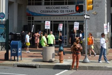  Members of the carpenters union protest outside the Pennsylvania Convention Center Monday. Postal workers are  having their annual meeting there. (Tom MacDonald/WHYY) 