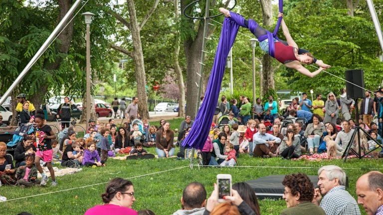 Nina Giacobbe takes to the silks during her performance with Tangle Arts in Clark Park. (Emily Cohen/for NewsWorks)