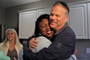1home donation Army veteran and single mother Janne Dawson hugs Gary Smith,  a Mullica Hill contractor who bought and renovated an abandoned home in Camden and gave it to her through Catholic Charities. (Emma Lee/WHYY)