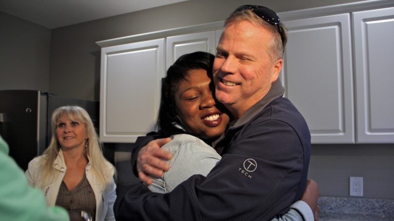 Army veteran and single mother Janne Dawson hugs Gary Smith,  a Mullica Hill contractor who bought and renovated an abandoned home in Camden and gave it to her through Catholic Charities. (Emma Lee/WHYY)