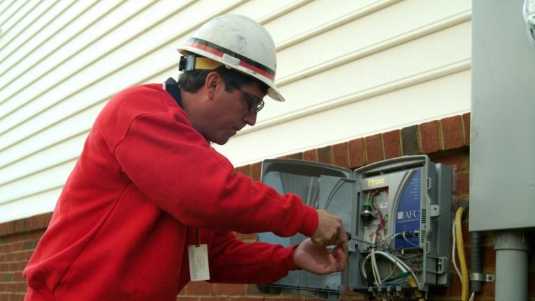  A Verizon technician installs a device, known as an optical network terminal (ONT), as part of the installation of all-fiber FiOS Internet and FiOS TV at a customer's house.(AP Photo/Verizon) 