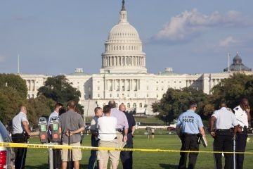  Law enforcement officers are near the scene on the National Mall in Washington, where a man set himself on fire Friday, Oct. 4, 2013. (AP Photo/J. Scott Applewhite) 