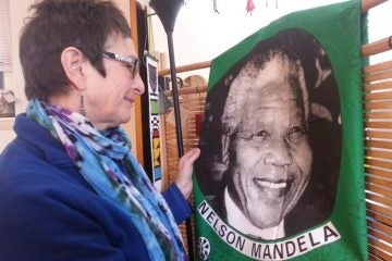  Marilyn Cohen looks fondly at a piece of Nelson Mandela memorabilia from her years in South Africa. (Aaron Moselle/WHYY) 