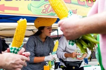  Jess Patrone serves roasted corn at the 'The Corn Lady' stand at the 2013 Manayunk StrEat Food Festival (Brad Larrison/for NewsWorks, file) 