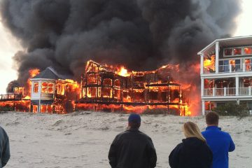  People watch as fire engulfs three homes in Sea Isle City, N.J. on Friday, April 18, 2014. (AP Photo/Joanne Dollarton) 