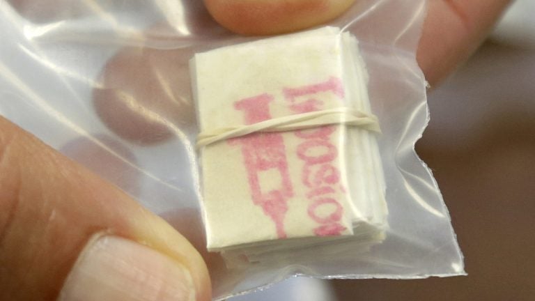  A detective in the Ocean County Prosecutors shows off a packet of confiscated heroin. (AP Photo/Mel Evans) 