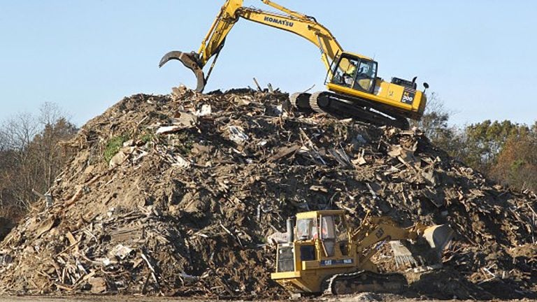  Heavy equipment operators work on a mountain of debris left by Superstorm Sandy. (Mel Evans/AP File Photo) 