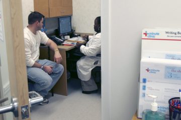 20141026-health-clinic-1200 Shanda Johnson, right, a nurse practitioner, interviews patient Bill Gilligan at a MinuteClinic at the CVS drug store in North Brunswick, N.J., (AP Photo/Mike Derer)