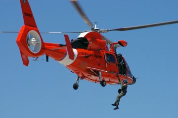  The boaters were rescued by the Coast Guard using a MH-65 Dolphin helicopter, like the one shown here. (FILE Photo by USCG) 