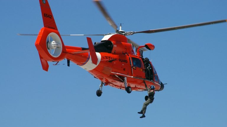  The boaters were rescued by the Coast Guard using a MH-65 Dolphin helicopter, like the one shown here. (FILE Photo by USCG) 