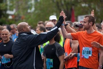  Philadelphia Mayor Michael Nutter high fives runners before the start of the 2014 Broad Street Run. (Brad Larrison/for NewsWorks) 