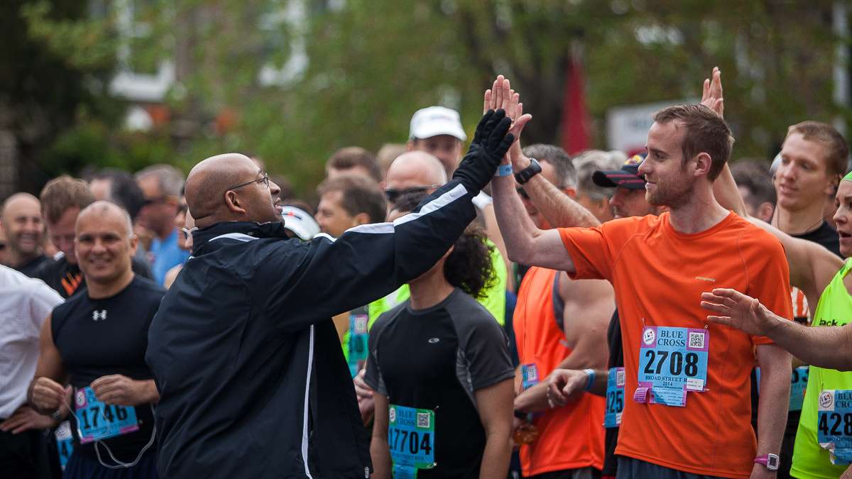  Philadelphia Mayor Michael Nutter high fives runners before the start of the 2014 Broad Street Run. (Brad Larrison/for NewsWorks) 