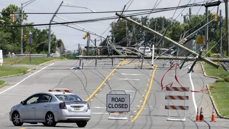  A driver turns her car at a closed road on June 24, 2015 after a violent storm downed poles and power lines  in Gibbstown, N.J. (AP Photo/Mel Evans) 