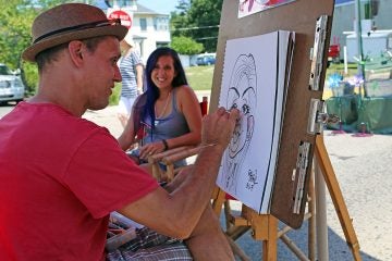 Caricature artist Frank Urbaniak working on a drawing at the 10th Annual Collingswood Crafts and Fine Art Festival (Natavan Werbock/for NewsWorks)