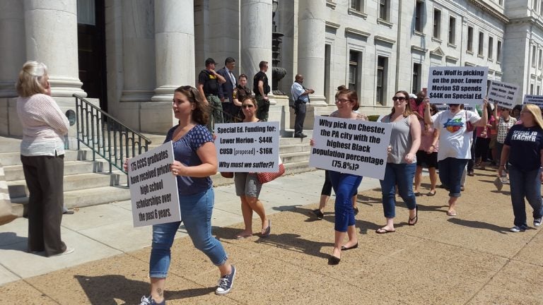  Parents and teachers march with their messages in front of the Chester County Courthouse Monday. (Laura Benshoff/WHYY) 