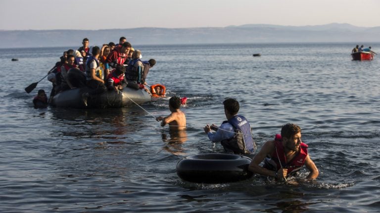  Migrants pull an overcrowded dinghy with Syrian and Afghan refugees arriving from the Turkish coasts to the Greek island of Lesbos, Monday, July 27, 2015. (AP Photo/Santi Palacios) 