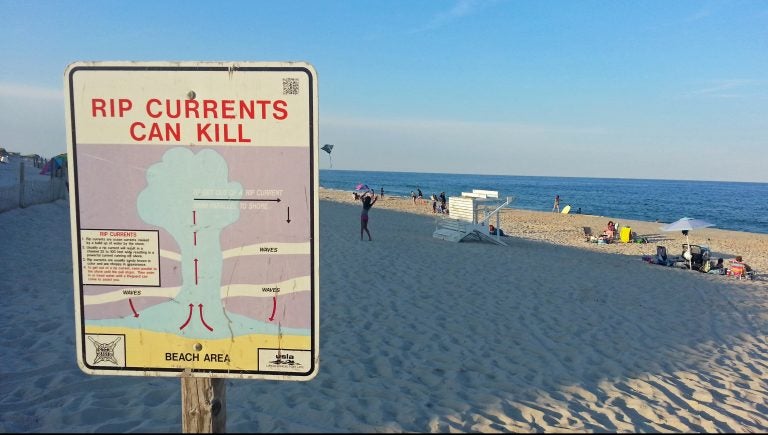 A sign in Cape May instructs swimmers caught in a rip current to swim parallel to the beach to escape. (Alan Tu/WHYY)