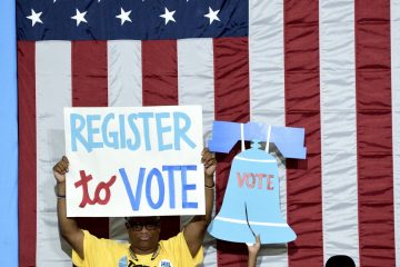 Participants carry signs at a voter registration event in West Philadelphia in August. (Bastiaan Slabbers for NewsWorks)