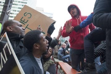  An unidentified spectator, right intervenes to diffuse a confrontation between Black Lives Matter protesters and several Mummers spectators. (Jonathan Wilson/for NewsWorks) 