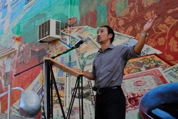 Thoai Nguyen of SEAMAAC (Southeast Asian Mutual Assistance Associations Coalition) which collaborated on the mural, speaks out against gambling, which he feels has a disproportionate impact on the Asian community. (Emma Lee/WHYY)