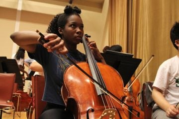 Tayana Woodton, a graduate of Girard Academy of Music, warms up before rehearsal with the All City Orchestra. (E