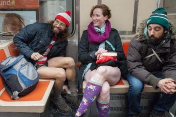 Friends who identified themselves as Waldo (left) and Koryn (center) participate in the  No Pants Subway Ride on the Broad Street line. (Jonathan Wilson for Newsworks)