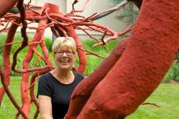  Lisa Hanover, curator of 'Out of this World: Works by Steve Tobin' at the Michener Museum, stands amid a piece called 'Romeo and Juliet,' which consists of bronze casts of a tree root system. (Nathaniel Hamilton/for NewsWorks) 