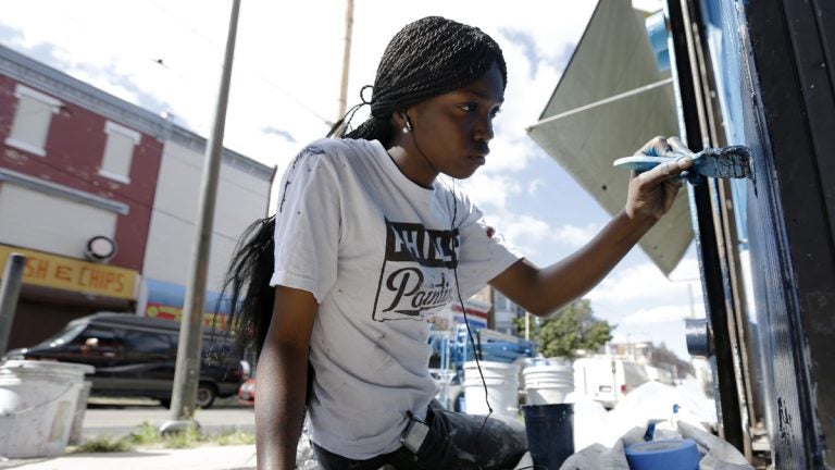  Natalie Glover paints a store front on a commercial corridor in North Philadelphia as part of the city’s renowned Mural Arts Program. Liz Dow names Mural Arts Executive Director, Jane Golden as a “spark” that inspires others. (AP Photo/Matt Rourke) 