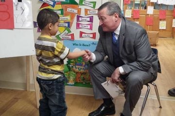 Philadelphia Mayor Jim Kenney shakes hands with a student at Kinder Academy