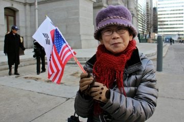 Joo Hwan Yi of Philadelphia waves the flags of the United Statesa and the Republic of Korea to celebrate Korean American Day. (Emma Lee/WHYY)